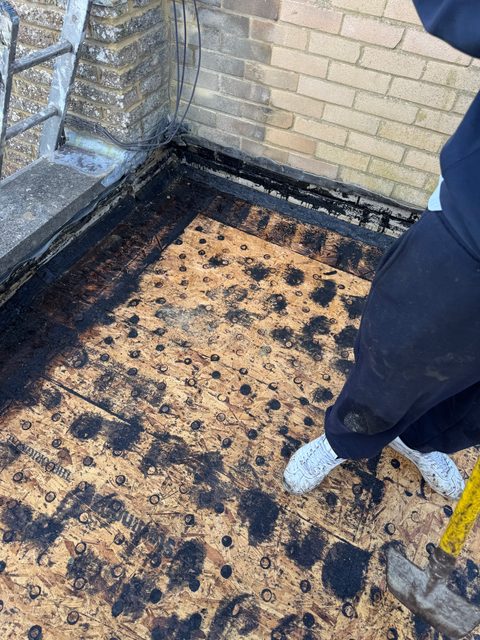 Storm Dry Roofing flat roof job: old felt stripped off back to the timber deck at the corner of the parapet walls
