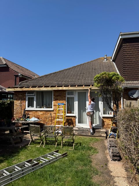 Storm Dry Roofing fascia job: old fascia and gutter coming off above the back doors of a bungalow